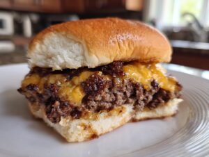 A close-up of a delicious juicy burger with melted cheese and caramelized onions on a bun.
