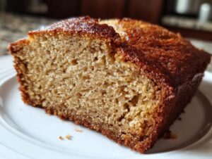 A close-up of a moist slice of homemade banana bread, showcasing its texture and golden-brown crust.