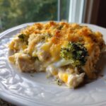 A close-up serving of creamy Chicken Divan featuring chunks of chicken, broccoli florets, and a golden, crunchy breadcrumb topping.