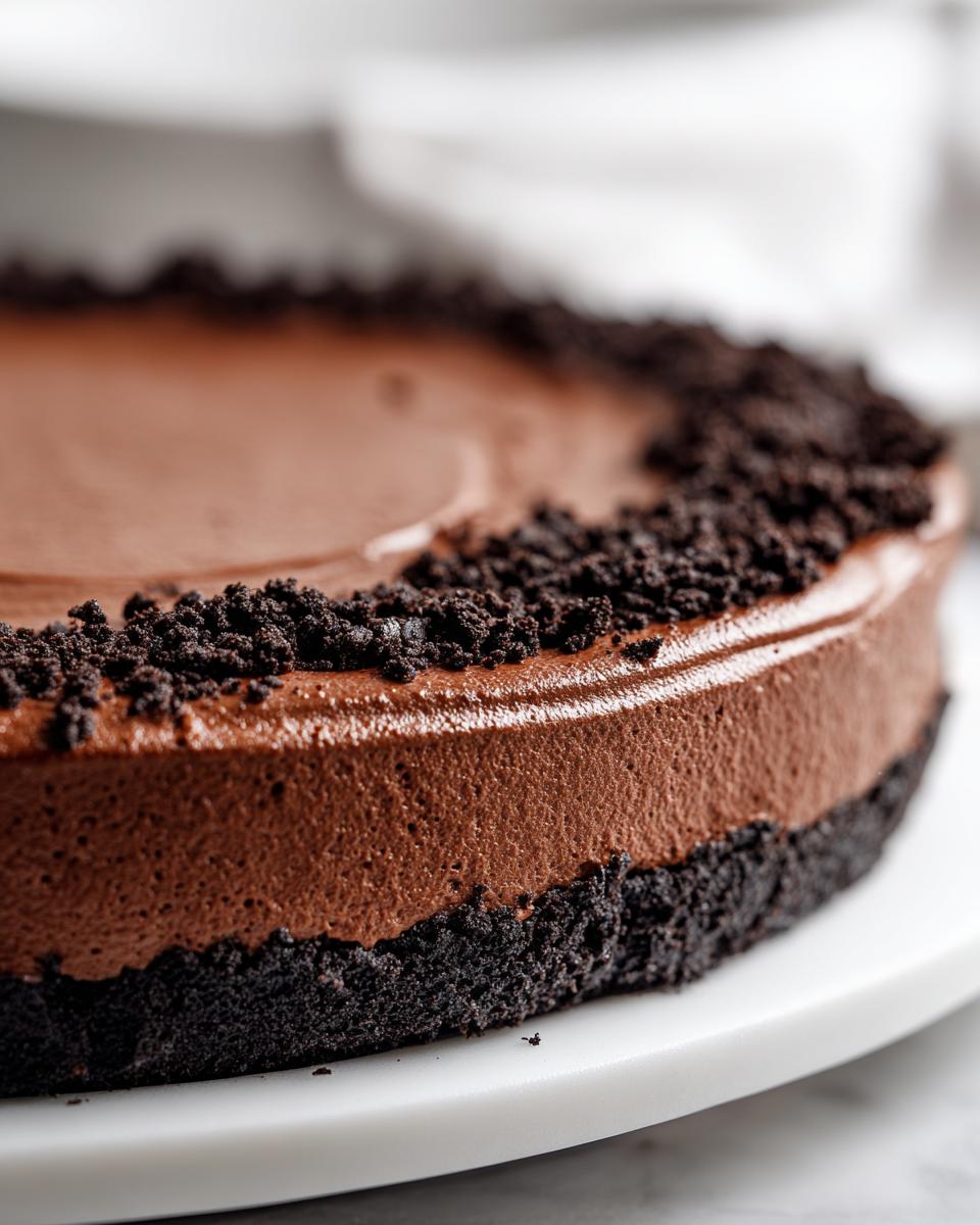 A close-up view of the rich, airy filling and dark cookie crust of a chocolate mousse pie.