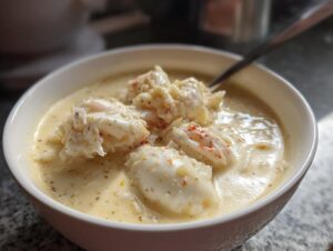 Close-up of a bowl of creamy she crab soup generously topped with large chunks of white crab meat.