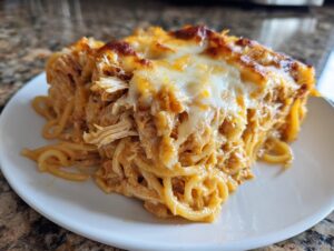 A generous slice of baked Monterey Chicken Spaghetti with shredded chicken and melted, bubbly cheese topping.