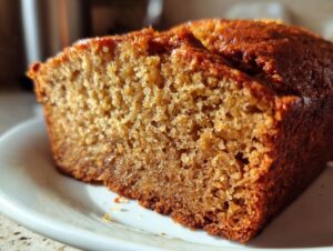 Close-up of a moist, golden-brown slice of banana bread showing its tender crumb texture.