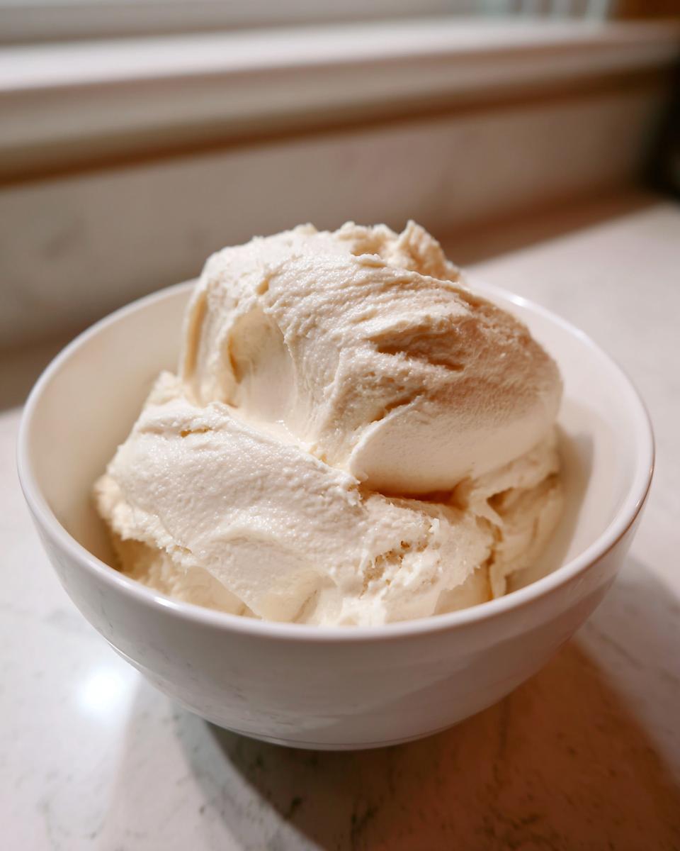 A white bowl filled with thick, creamy homemade cream of chicken soup base, ready to be used.