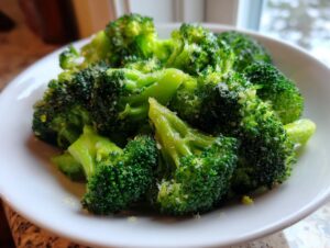 Close-up of bright green steamed broccoli florets seasoned with salt, ready to eat.